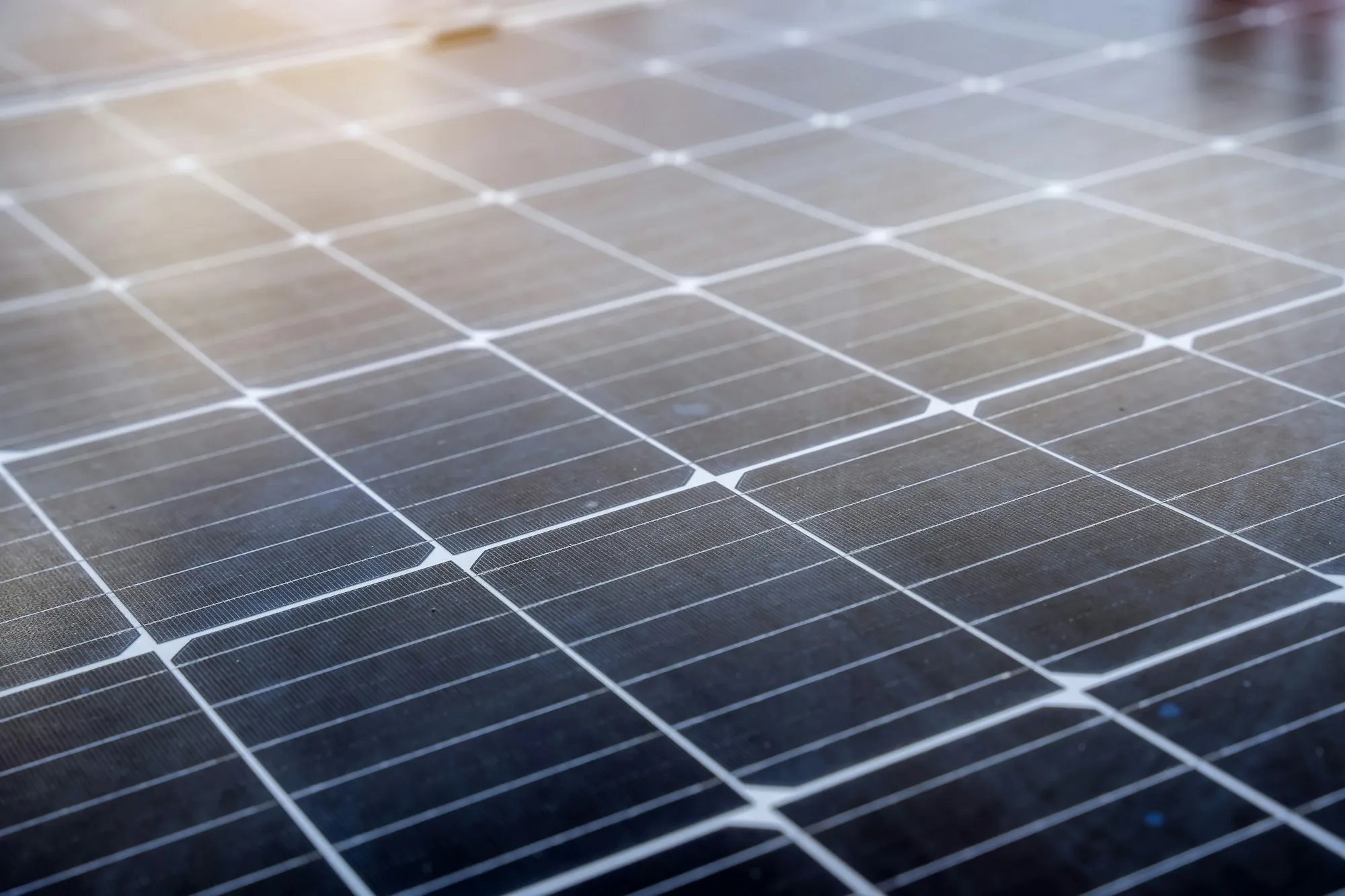Close-up of solar panel cells with soft light across the glass