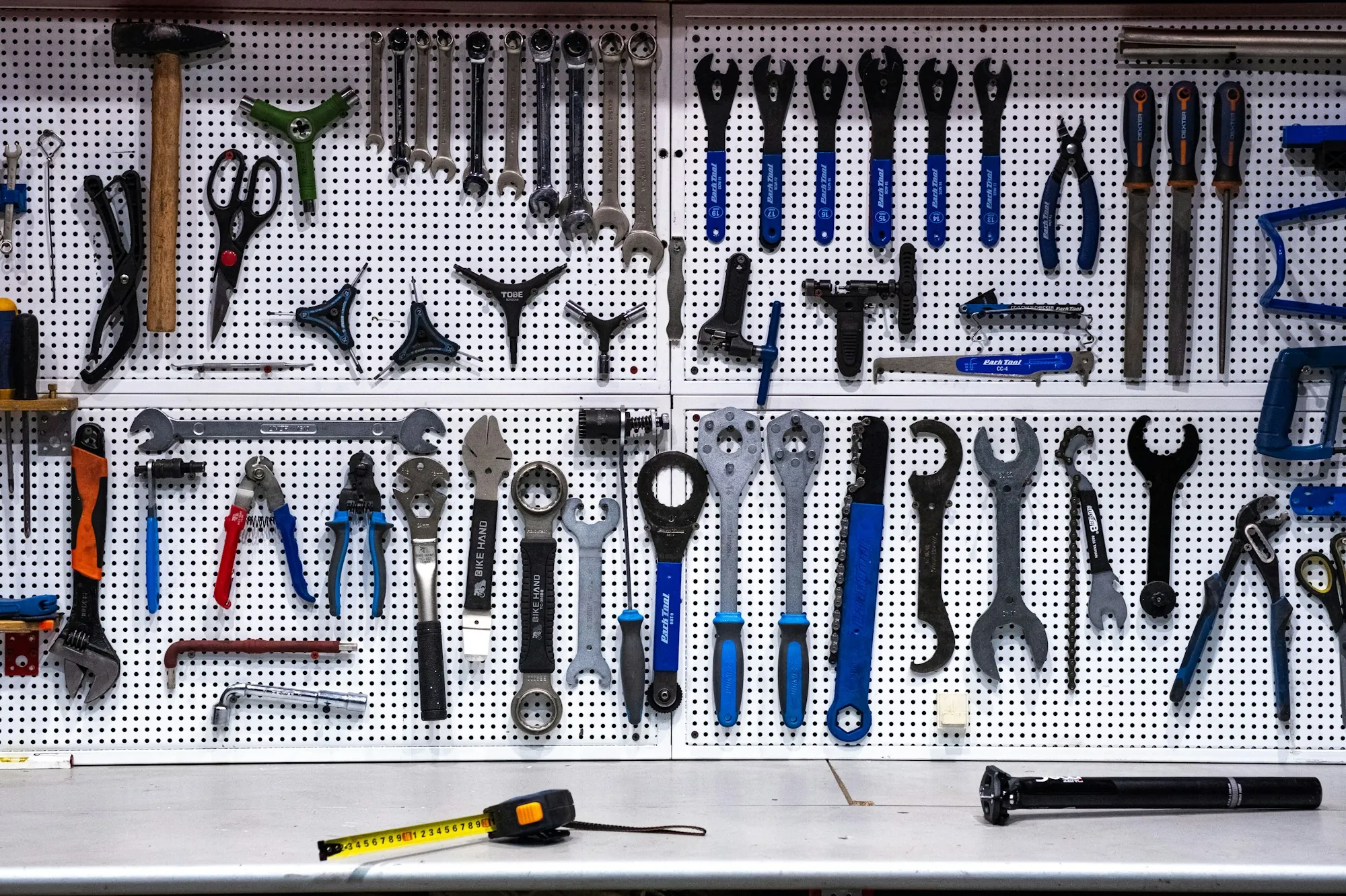 Pegboard wall full of pliers, wrenches and hand tools